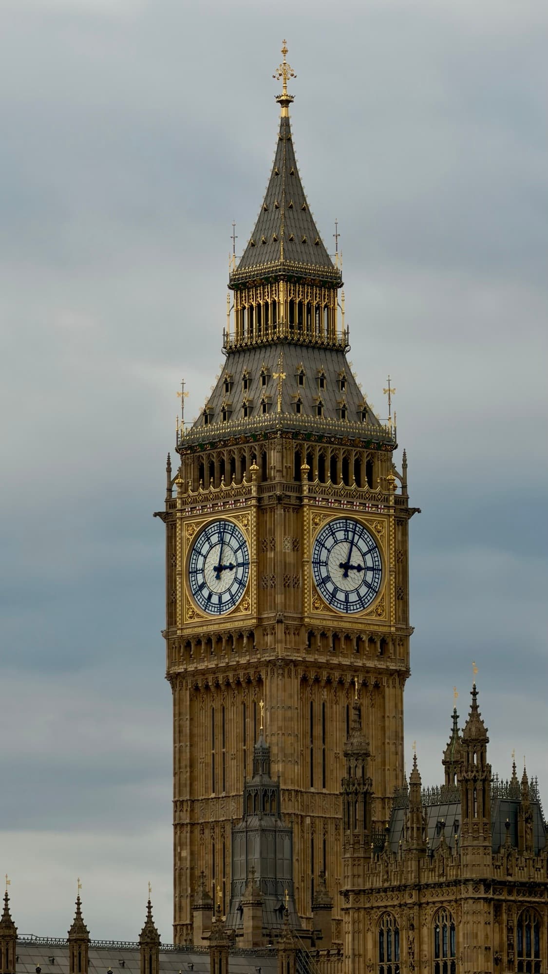 The Elizabeth Tower at Westminster under flat grey cloud, both clock faces reading just after ten to two.